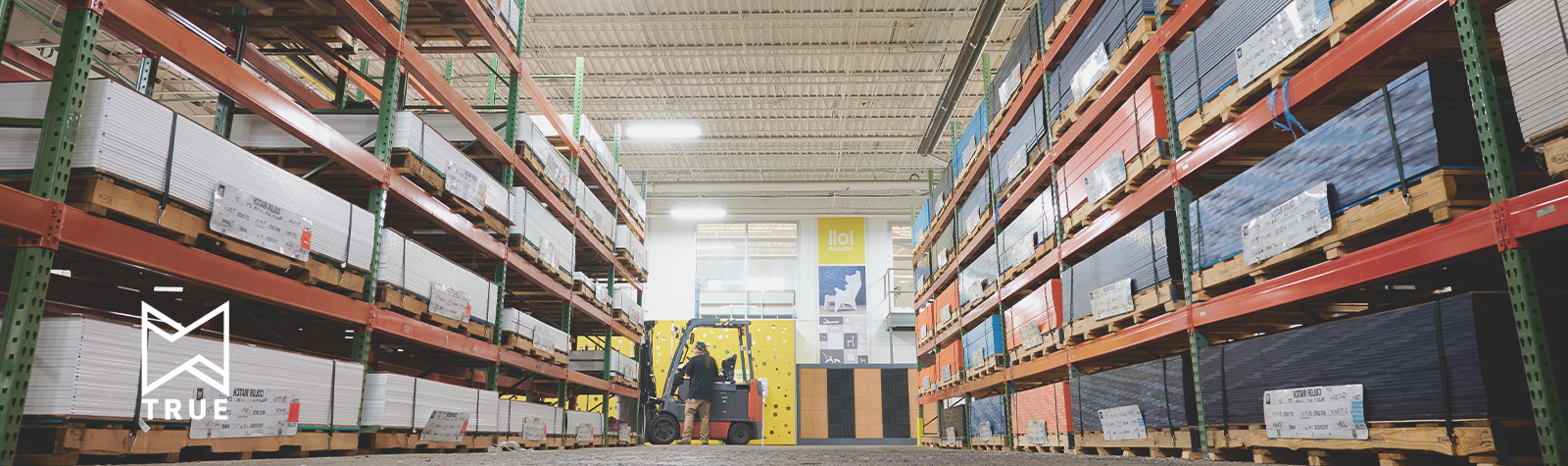 Image: True logo in the left hand corner. The image is of a warehouse with sheets of HDPE Poly stacked in racking. 